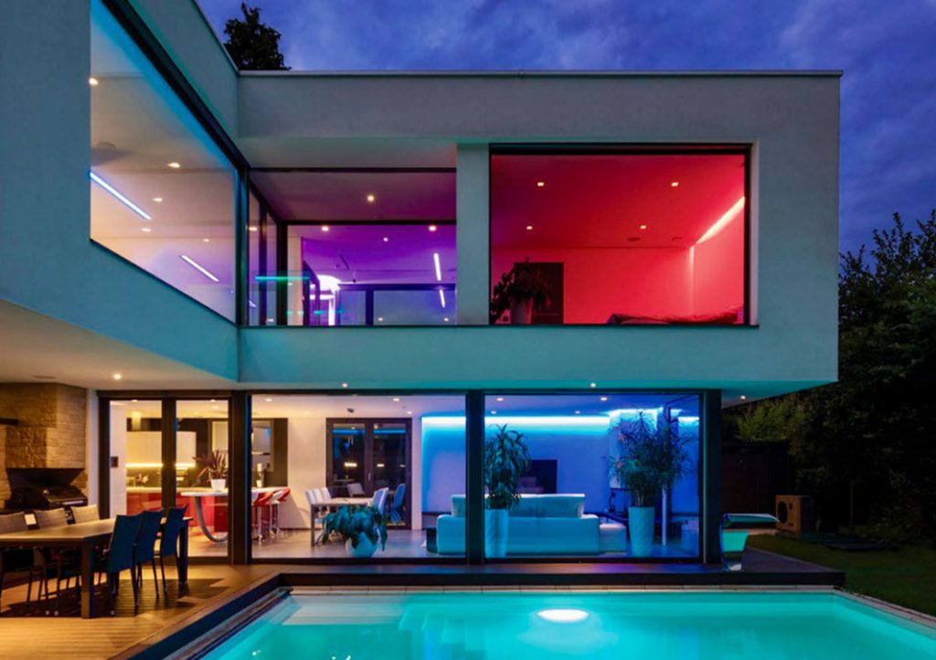 Modern home with dynamic LED lighting design in multiple colors illuminating interior and exterior spaces